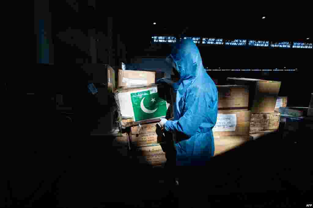 A staff member in Wuhan carries medical supplies sent from Pakistan at an exhibition center that has been converted into a makeshift hospital.