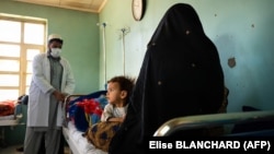 A doctor talks with a patient and her child at the Tangi Saidan clinic run by the Swedish Committee for Afghanistan in the Daymirdad district of Wardak Province.