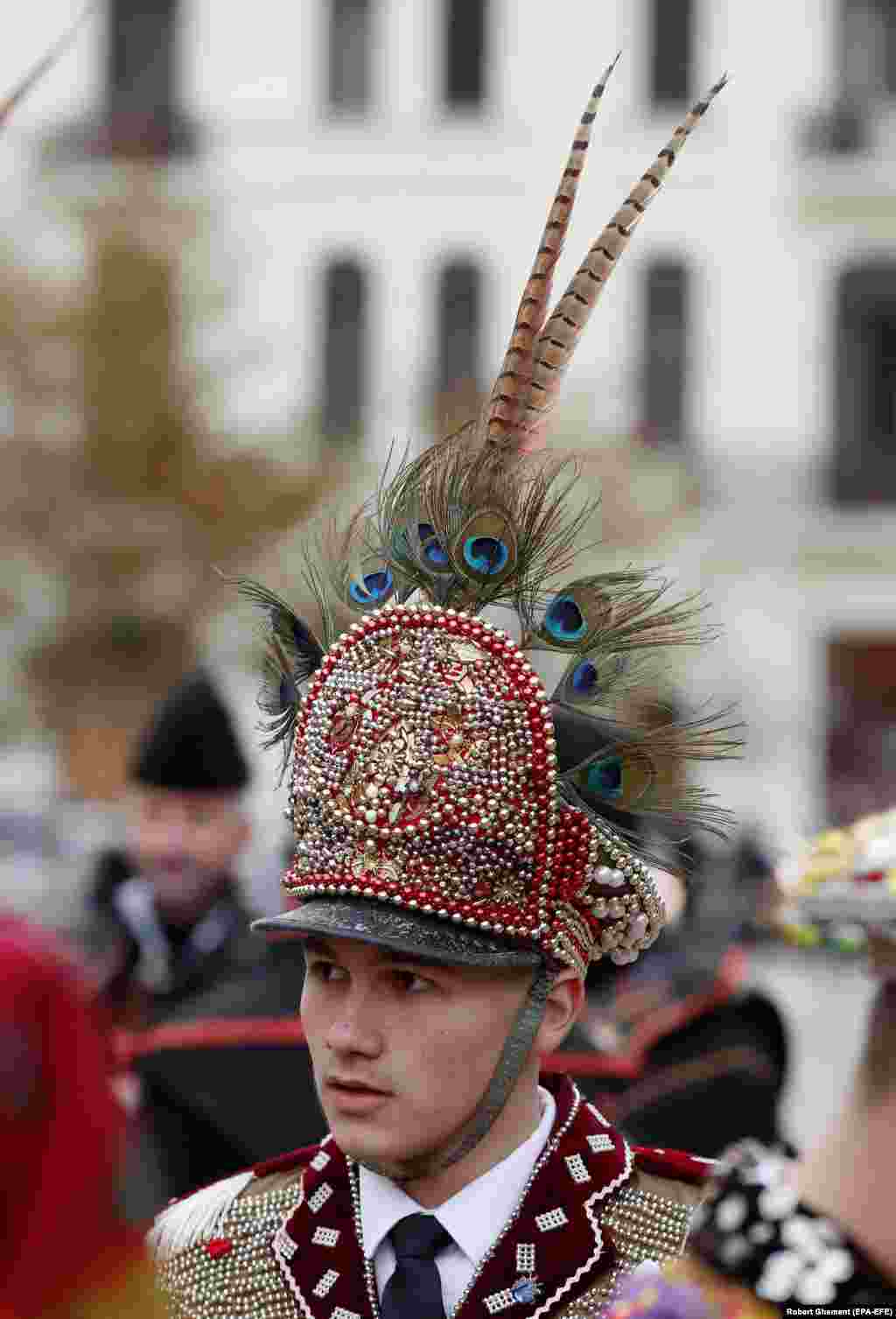 Učesnik festivala nosi šešir ukrašen paunovim perjem. Događaj je okupio ljude koji različito baštine zimsku tradiciju Rumunije.
