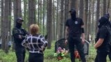 Люди в черном окружили женщину, пришедшую на акцию памяти в Сандармохе