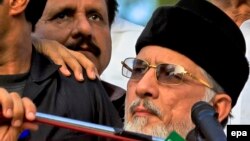 Tahirul Qadri (R), a Pakistani-Canadian cleric, is surrounded by security personnel as he speaks to supporters during protest in Islamabad, Pakistan.