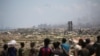 Palestinci posmatraju palete s humanitarnom pomoći kako se spuštaju padobranima iznad Nuseirata, u centralnom Pojasu Gaze, 5. avgusta 2025.
