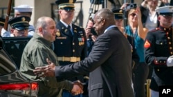 Secretarul american al Apărării, Lloyd Austin (dreapta), îl salută pe ministrul ucrainean al Apărării Rustem Umerov la Washington, D.C. , 2 iulie 2024.