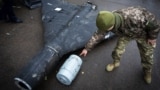 Украинский военный показывает термобарический заряд сбитого беспилотника Shahed, запущенного российской армией по цели в Украине